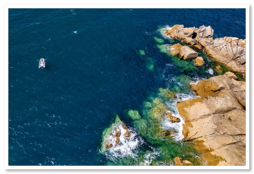 Pêcheur de bar dans son embarcation vue du ciel près des rochers