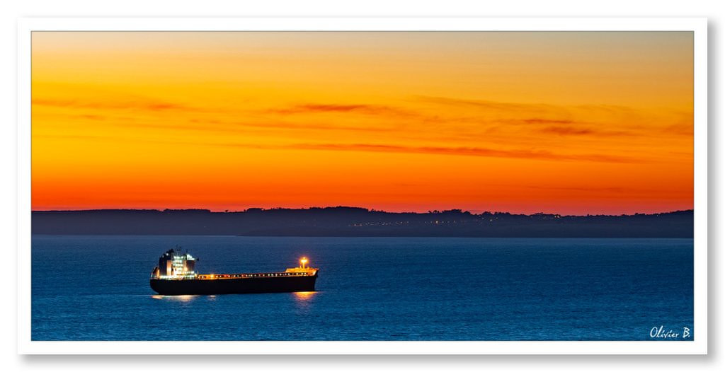 Magnifique coucher de soleil sur le cargo Pegasos en baie de Douarnenez, sous un ciel en feu, devant la presqu&#039;île de Crozon