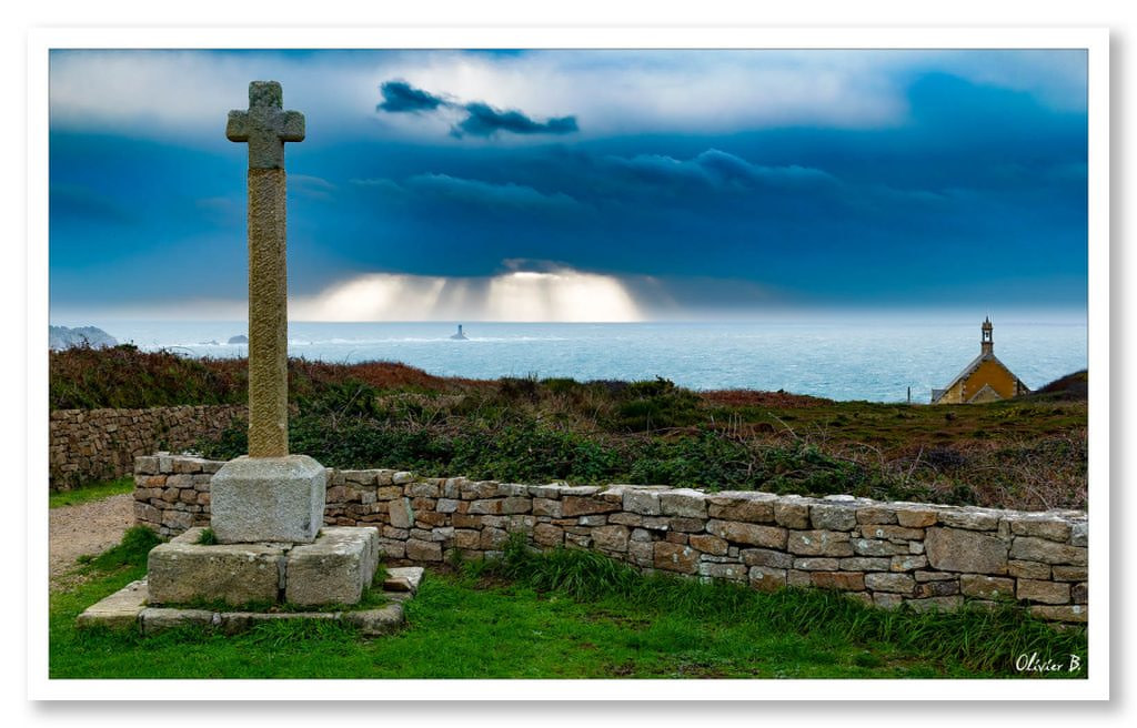 depuis la Pointe du Van, entre la chapelle et la croix en granit, le ciel s&#039;ouvre sur le phare de la Vieille