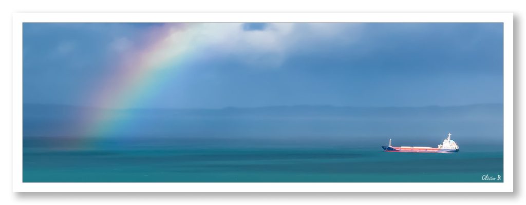 Un navire défiant un arc-en-ciel au-dessus de l&#039;océan limpide, symbole de résilience et d&#039;aventure maritime