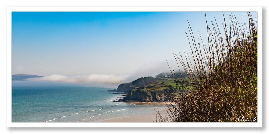 Un nuage fatigué se repose sur les majestueuses falaises surplombant l&#039;océan