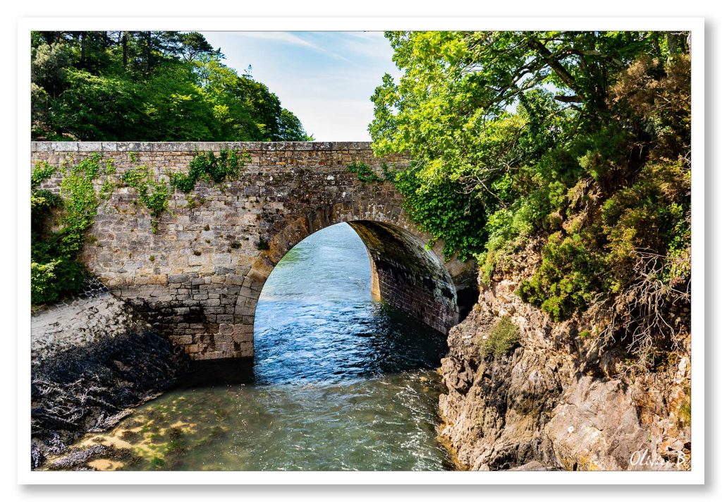 Petit pont de pierre à Audierne, laissant passer l&#039;eau de la rivière vers l&#039;océan